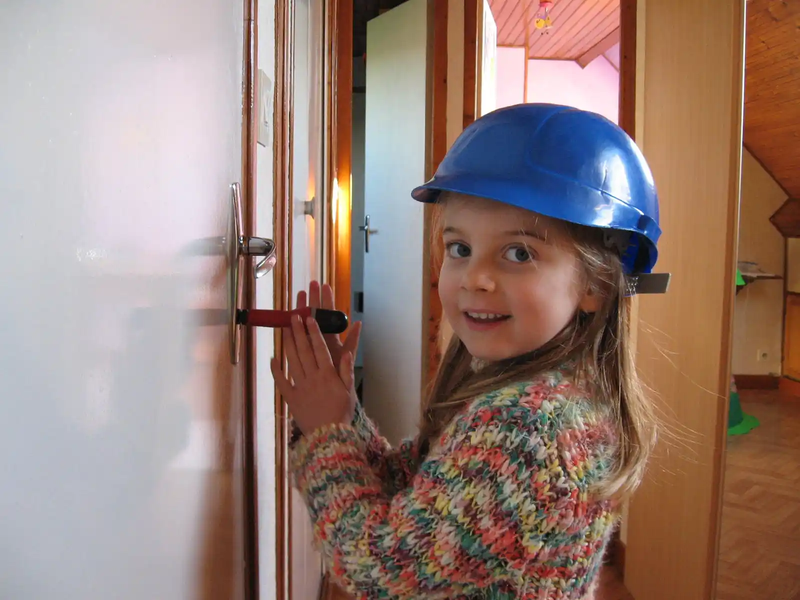 photo_laureen_enfant_bricoleuse Photo de la fondatrice de Koïlors, enfant en train de bricoler avec un casque de chantier.
